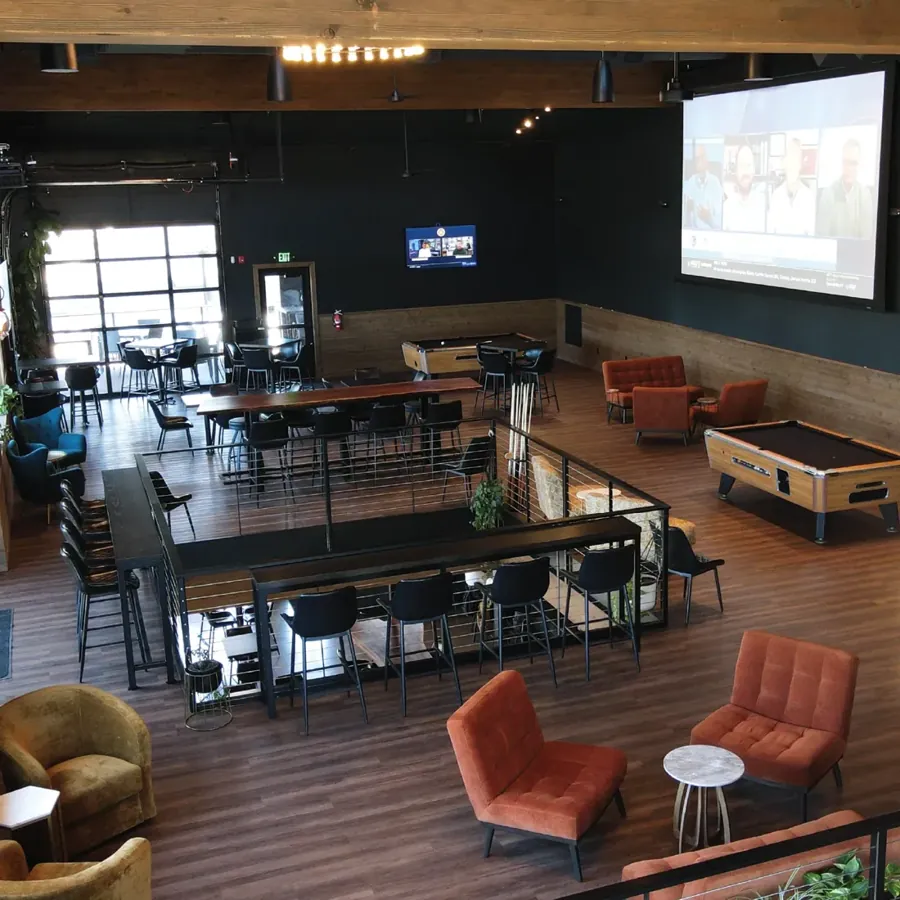 The indoor seating area and big projection screen at Base Camp in Bend