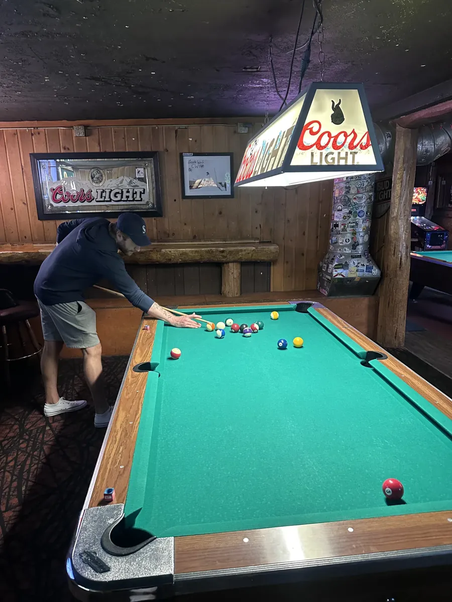 A pool game under a Coors Light lamp at Cascade West Grub & Alehouse, a dive bar on Century Drive in Bend, Oregon