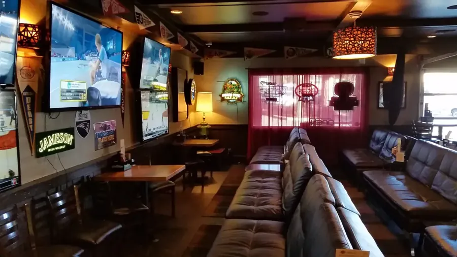 Booths and wall-mounted TVs inside a Hideaway Tavern sports bar in Bend
