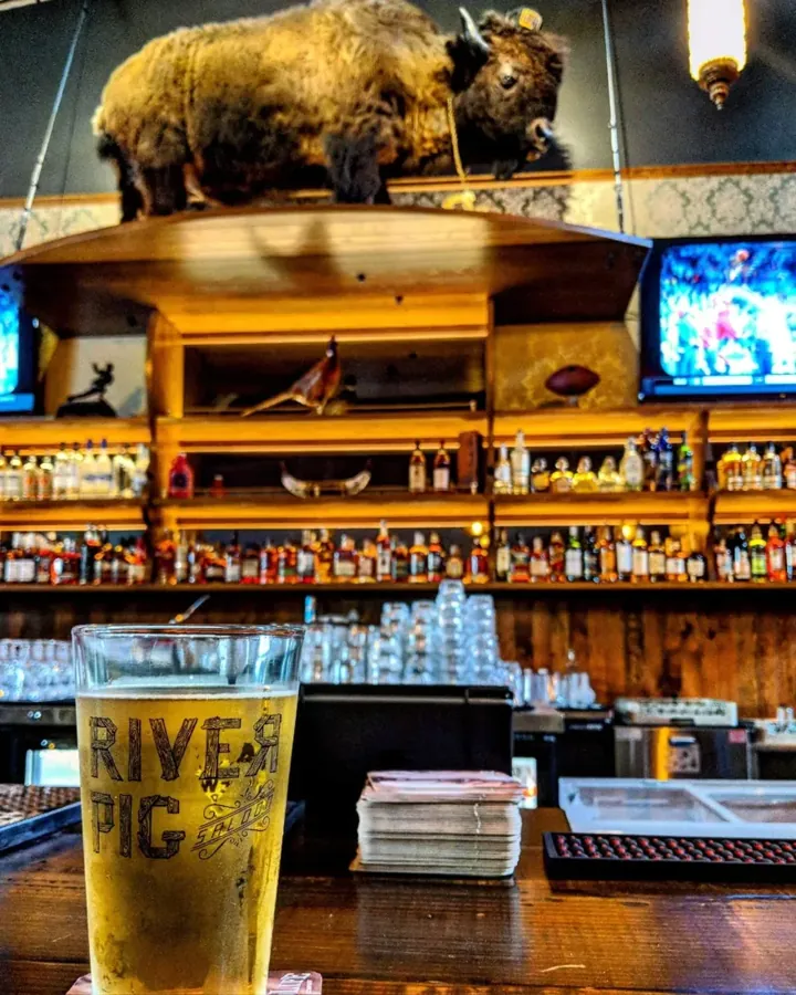 A River Pig pint glass in front of the back bar at River Pig Saloon in Bend