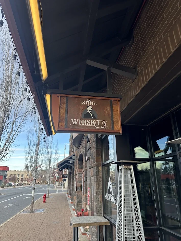 The wooden hanging sign outside The Stihl Whiskey Bar on Franklin Avenue in downtown Bend, Oregon