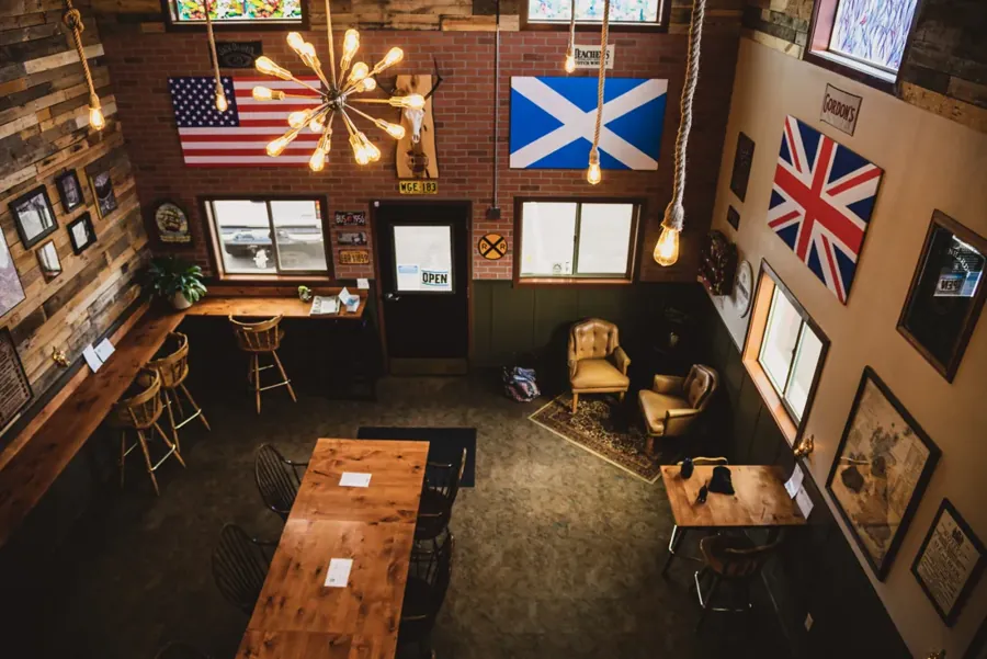 The basement pub room with flags on the ceiling at The Cellar in downtown Bend