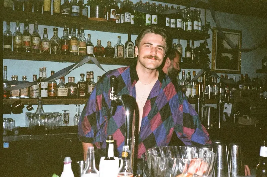 A bartender behind the bottle-lined bar at The Flamingo Room in Bend