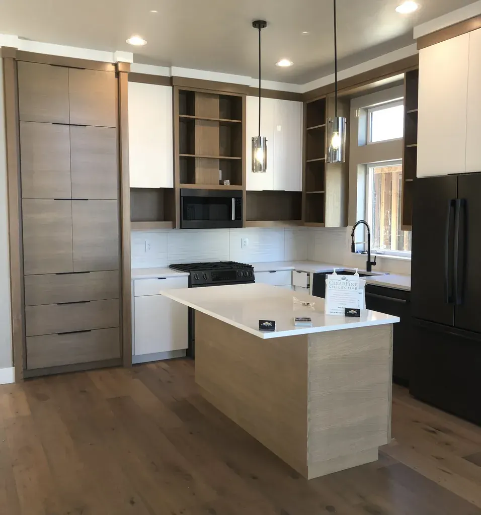 Light wood frameless kitchen with a tall pantry wall by Andreas Cabinetry