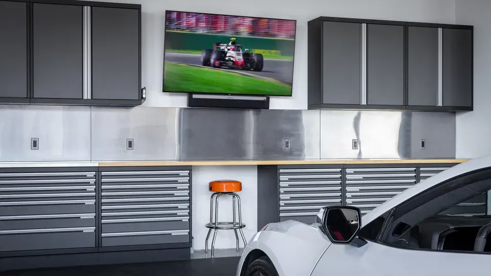 Gray powder-coated metal garage cabinets with a wall TV by Baldhead Cabinets