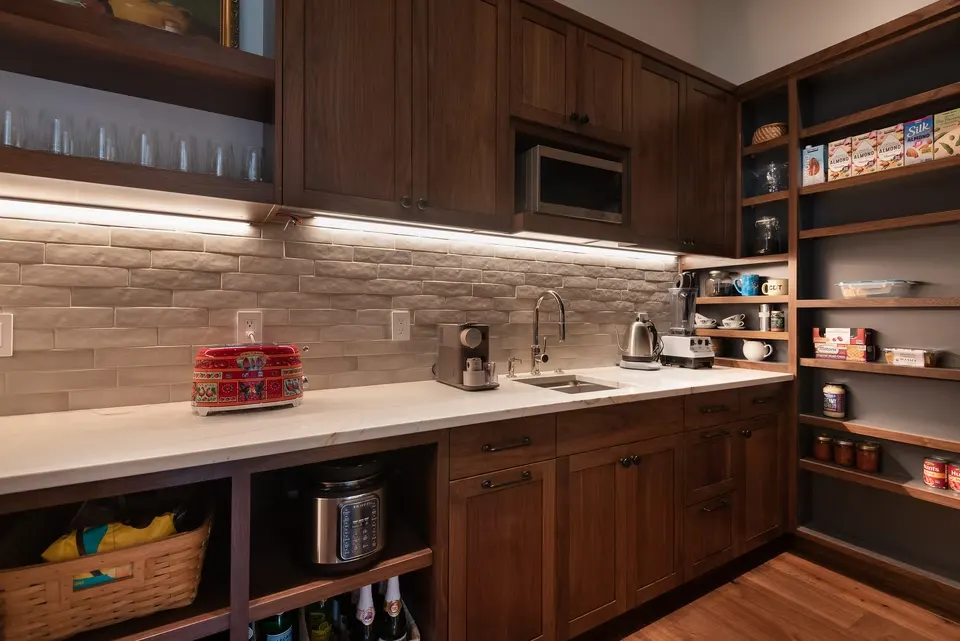 Dark walnut kitchen with open shelves and under-cabinet lighting by Bladt's