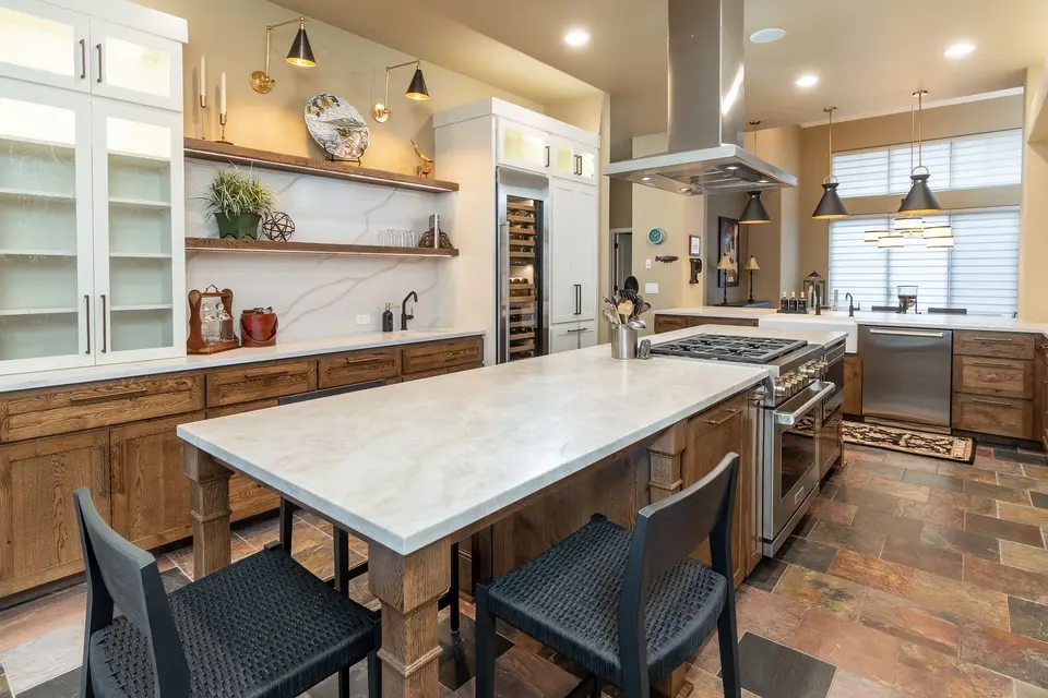 Stained kitchen with a white quartz island by JBL Cabinets