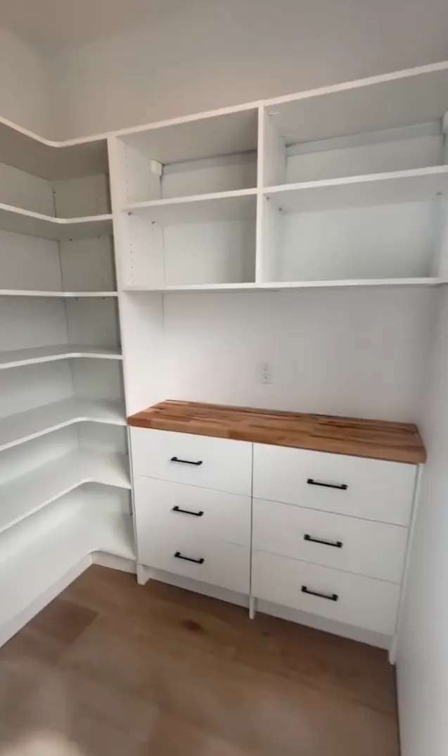 A white pantry system with drawers and a wood counter by Oregonized Closets