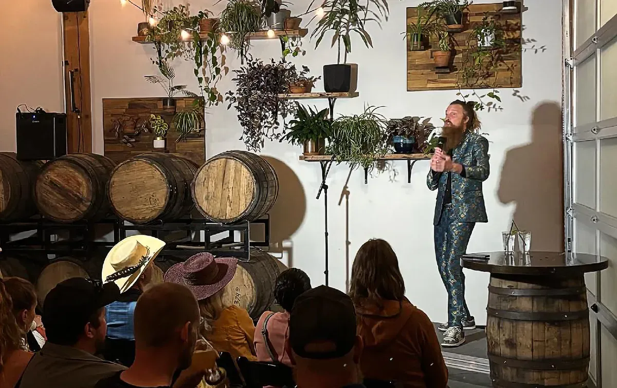 Bend Comedy performers and a crowd at a show among barrels