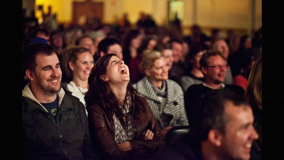 An audience laughing hard at a Bend Comedy show