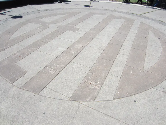 A large decorative circle pattern scored into a concrete plaza in Bend