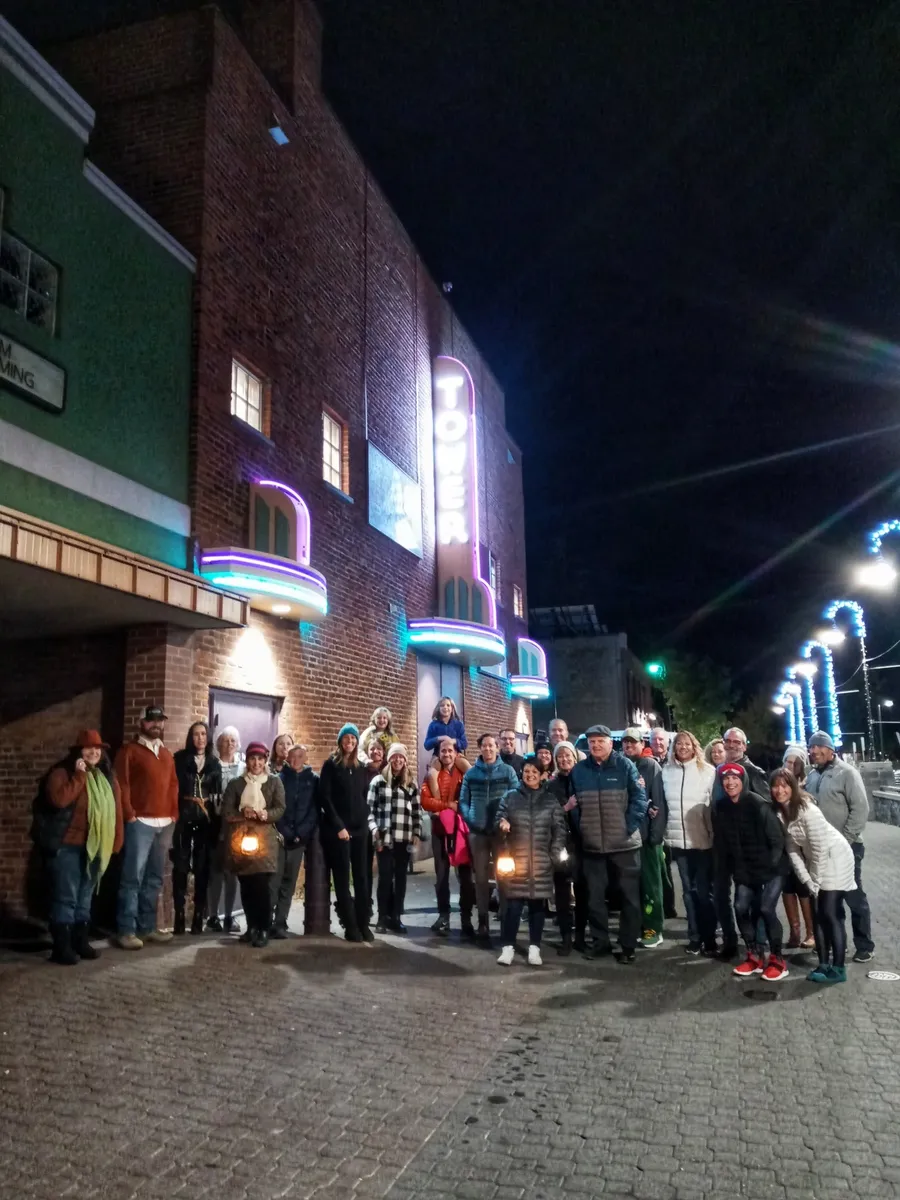 A Bend Ghost Tours group gathered on a downtown street at night