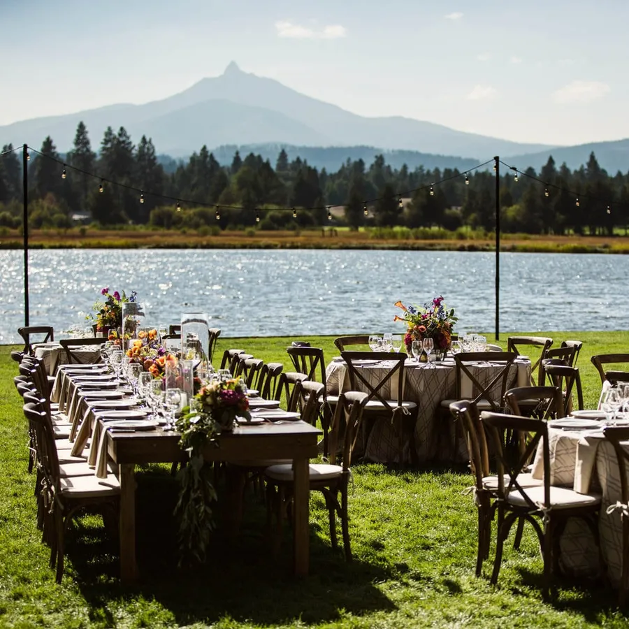 A long outdoor dinner table by the lake with Black Butte behind it at Black Butte Ranch