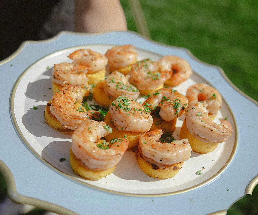 A platter of grilled shrimp on polenta rounds from Bleu Bite Catering
