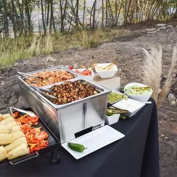 A Bowtie Catering buffet set up outdoors among junipers and high-desert grasses