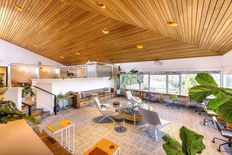 The coworking lounge with plants and work tables at The Haven in Bend