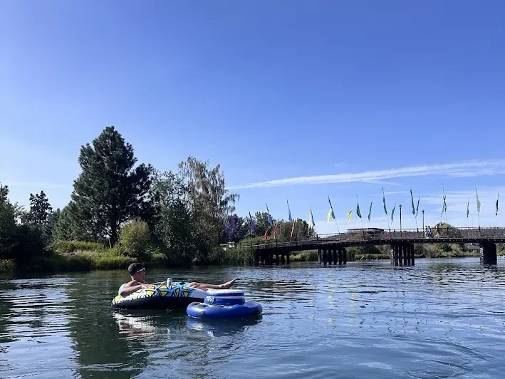 People floating the Deschutes River on inner tubes near the Old Mill District footbridge