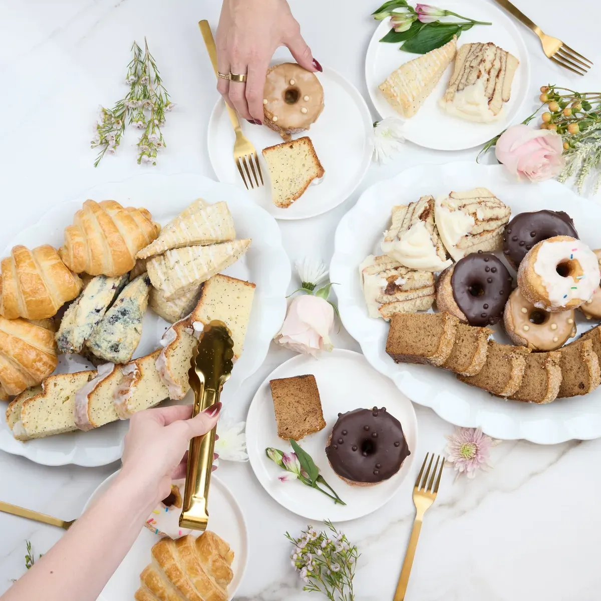 A spread of pastries, donuts, croissants and coffee on a table
