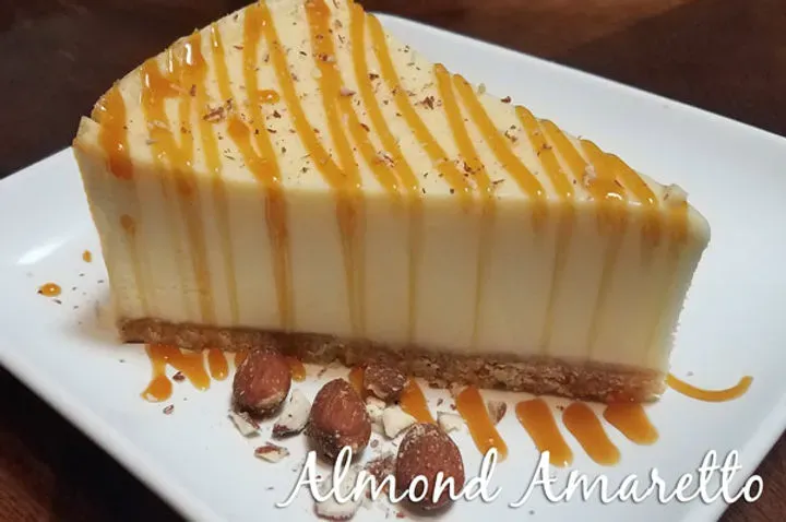 A slice of almond amaretto cheesecake with caramel drizzle