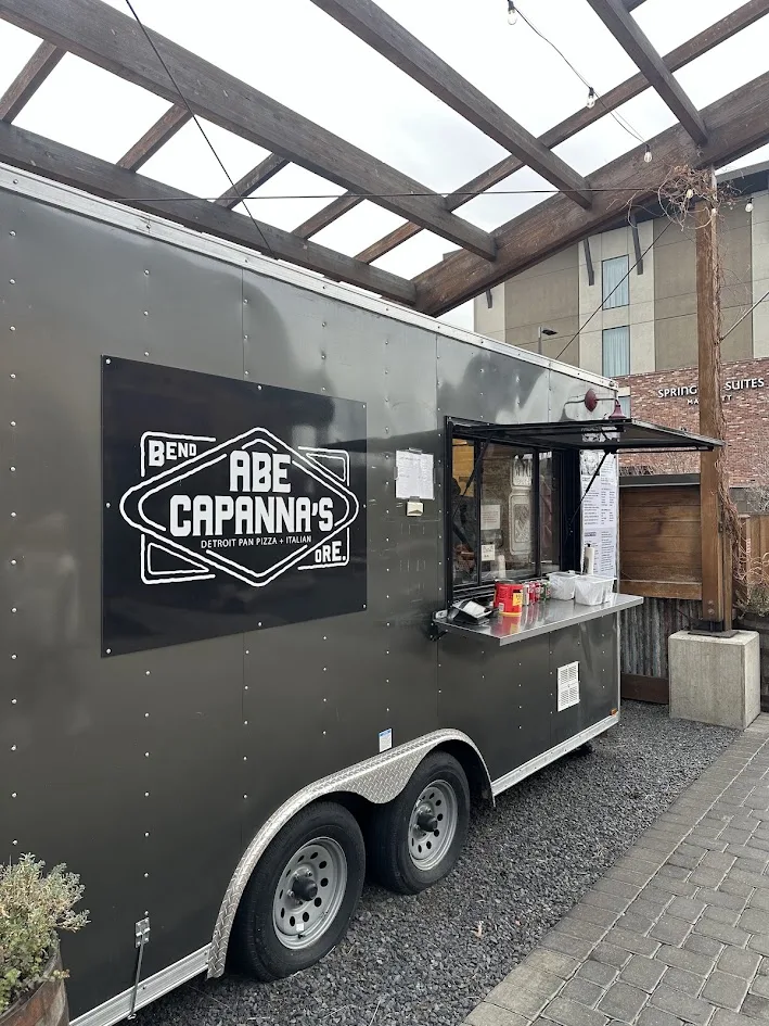 The Abe Capanna’s Detroit pan pizza cart under the timber pergola at Crosscut Warming Hut No. 5 in Bend, Oregon