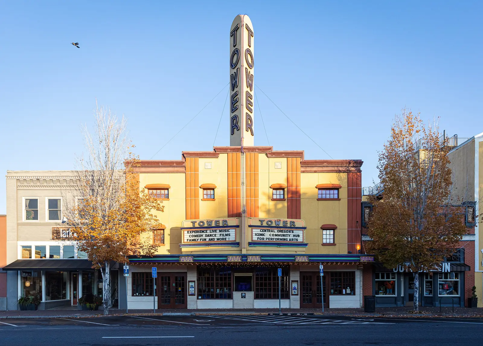 The Tower Theatre’s neon marquee and fall trees on Wall Street in downtown Bend