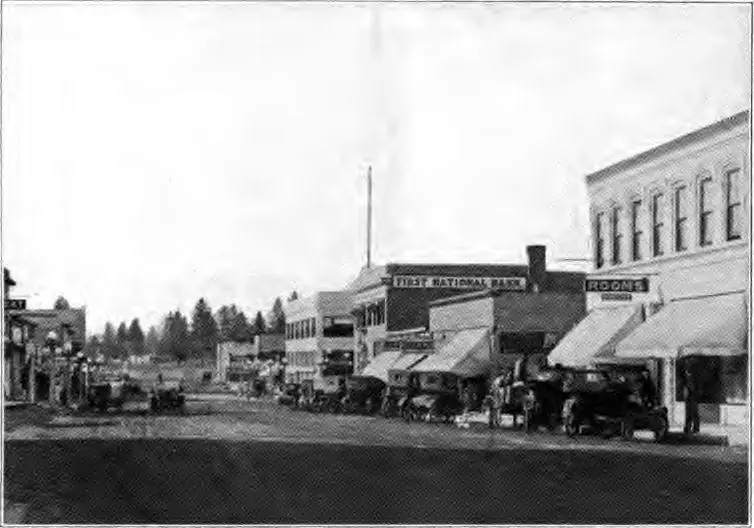 Black-and-white photo of Bond Street in downtown Bend around 1920, with storefronts and early cars