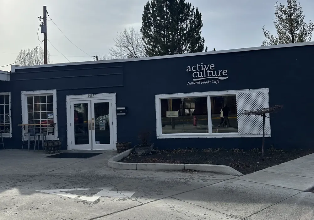White-framed glass double doors on a navy blue cafe storefront on a Bend side street