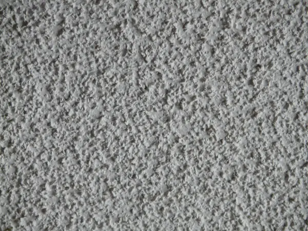 Close-up of a bumpy white popcorn ceiling texture