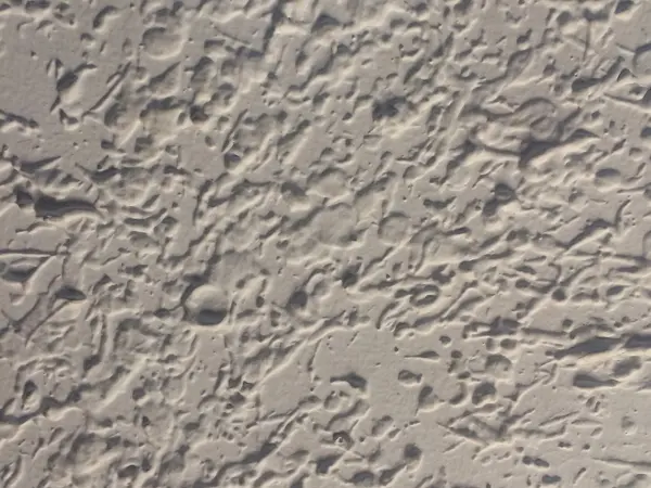 Close-up of a textured drywall ceiling with flattened knockdown-style islands