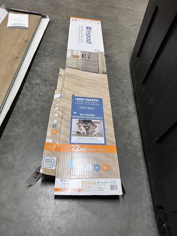 Box of rigid core vinyl plank flooring labeled 22 mil wear layer
