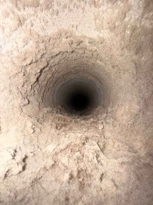 Looking into a round dryer vent duct packed with lint