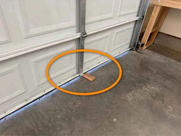 Wood block under a closed garage door during an auto-reverse test