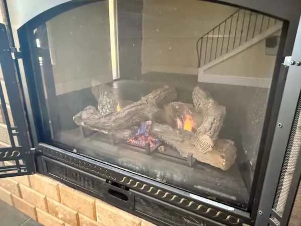 Gas fireplace with a tall orange flame behind glass