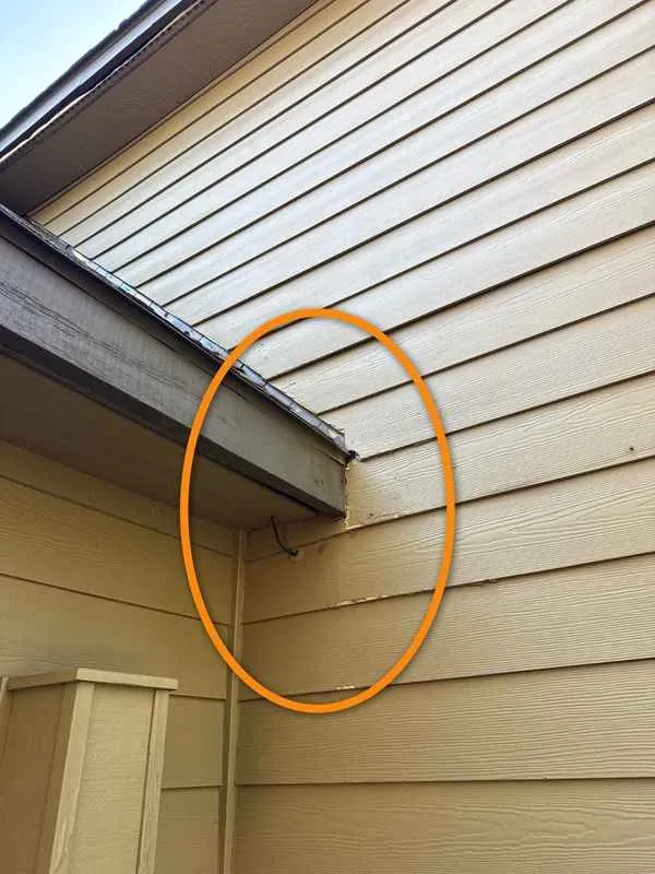 Spot where a roof edge ends against a sided wall with no kick-out flashing