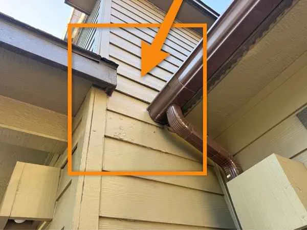 Upper roof edge draining straight onto siding where two rooflines meet