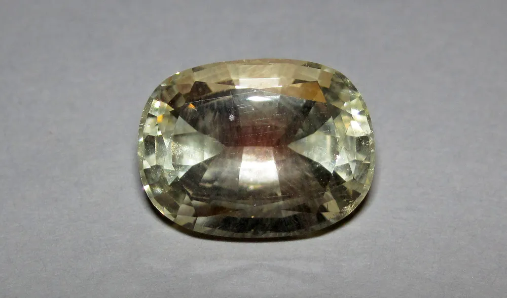 A large faceted pale champagne Oregon sunstone with a soft pink glow at its center