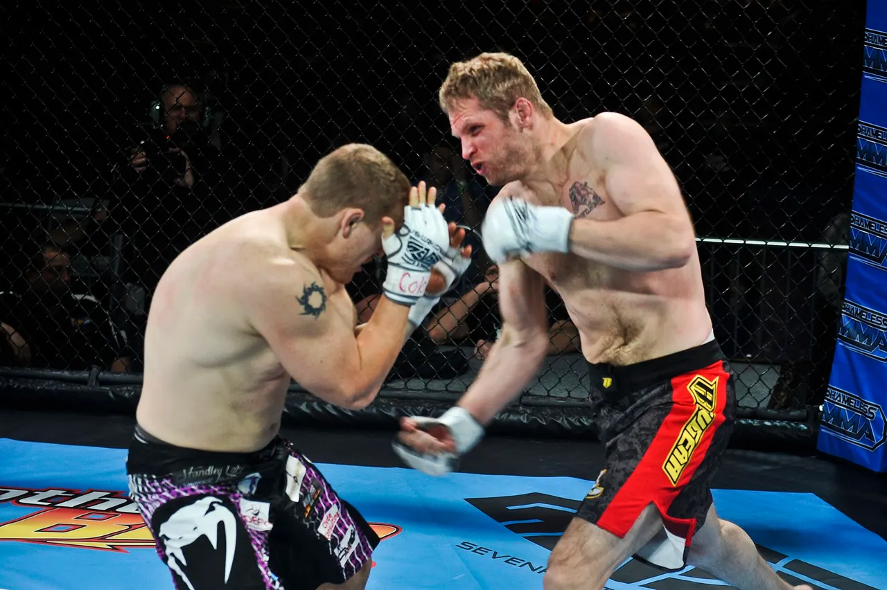 Two MMA fighters in open-finger gloves trade punches inside a cage under bright lights