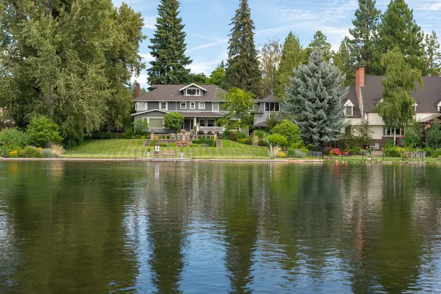 Homes and big pines reflected in Mirror Pond on the Deschutes River