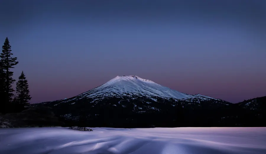 Snow-covered Mt. Bachelor at dawn under a purple sky