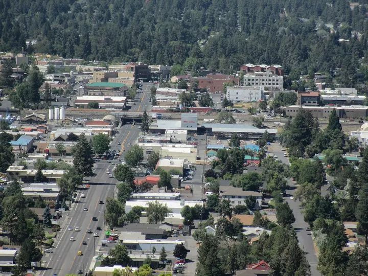 Downtown Bend seen from the top of Pilot Butte, with Greenwood Avenue, low buildings and ponderosa pines