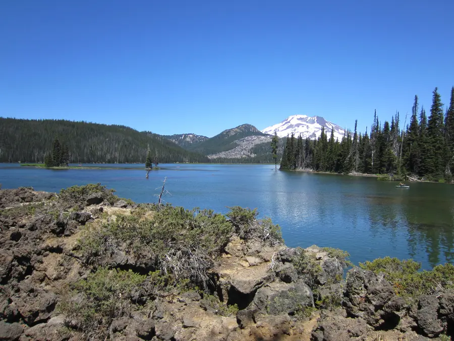 Sparks Lake with lava rock in the foreground and South Sister and Broken Top behind