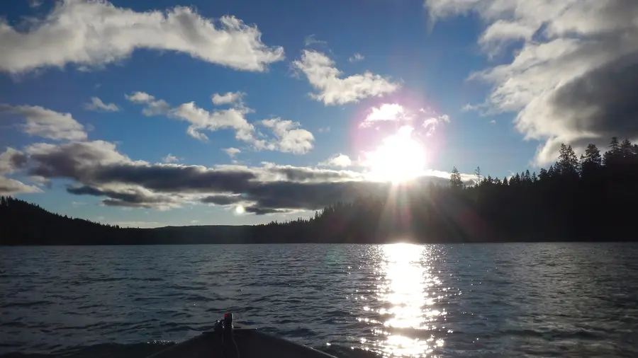 Sun rising over the forested shore of Suttle Lake