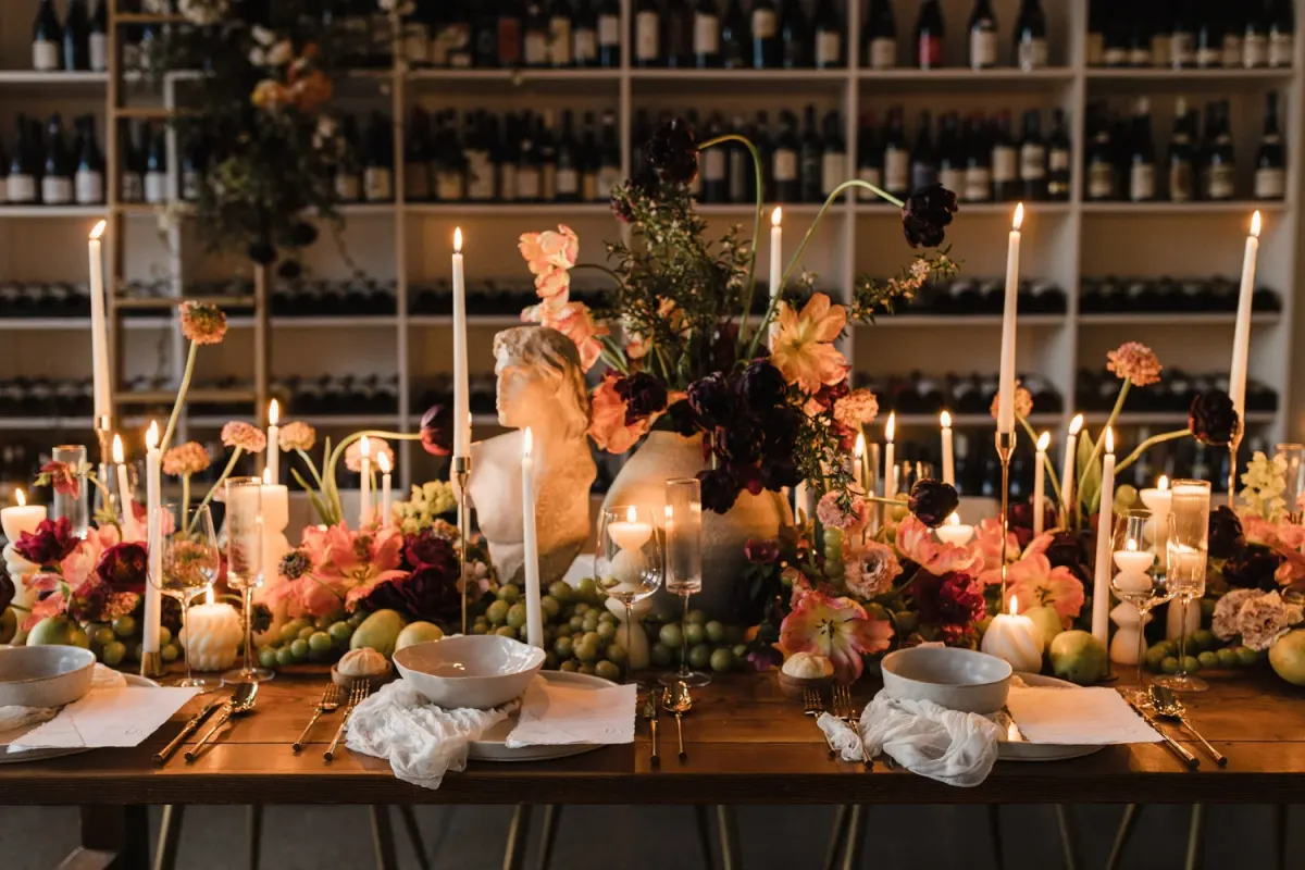 A candlelit table set in front of the wine wall at Viaggio Wine Merchant in Bend
