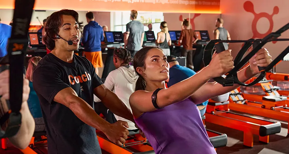 An Orangetheory class working on suspension straps