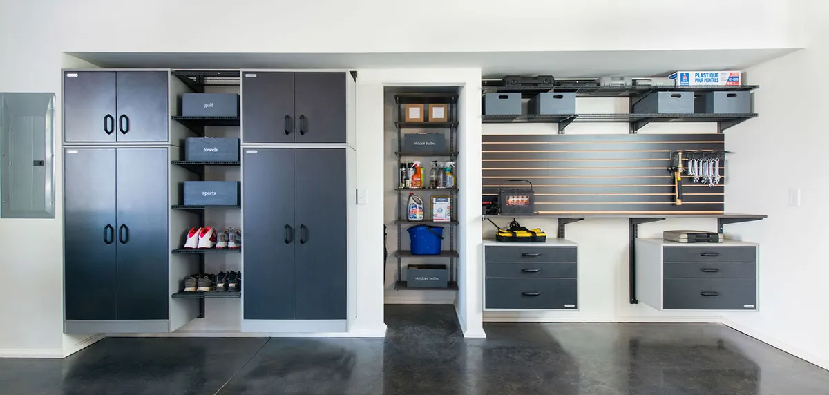 A custom garage wall system with cabinets and hanging storage