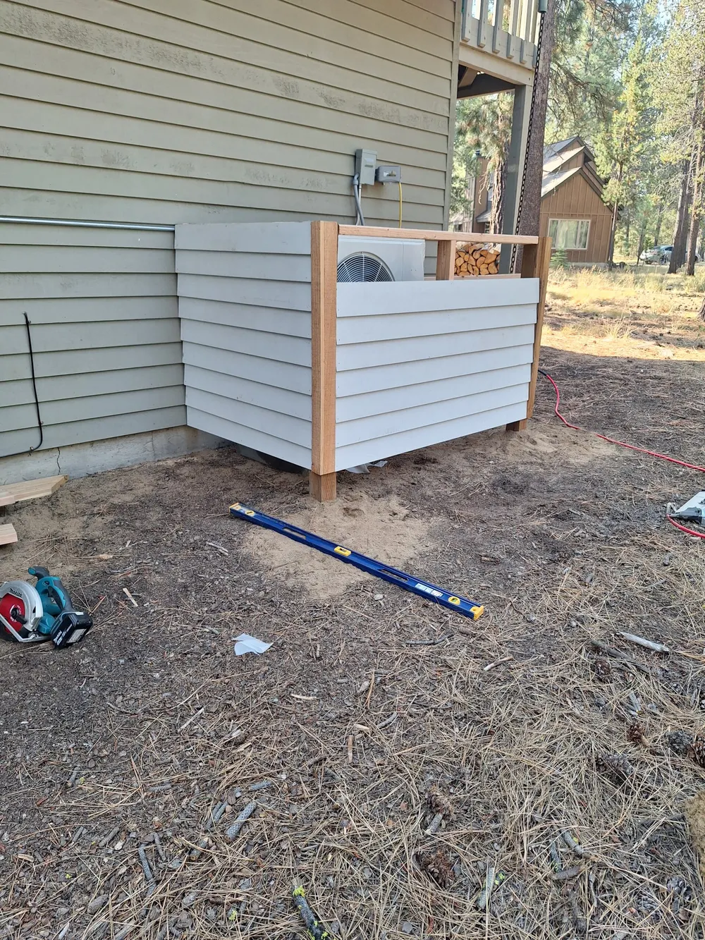 A wood screen built around a heat pump beside a Sunriver home
