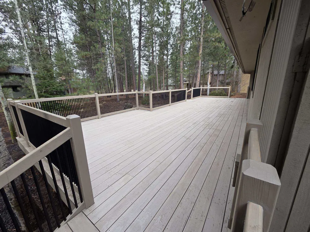 A rebuilt deck with gray railings among ponderosa pines in Sunriver