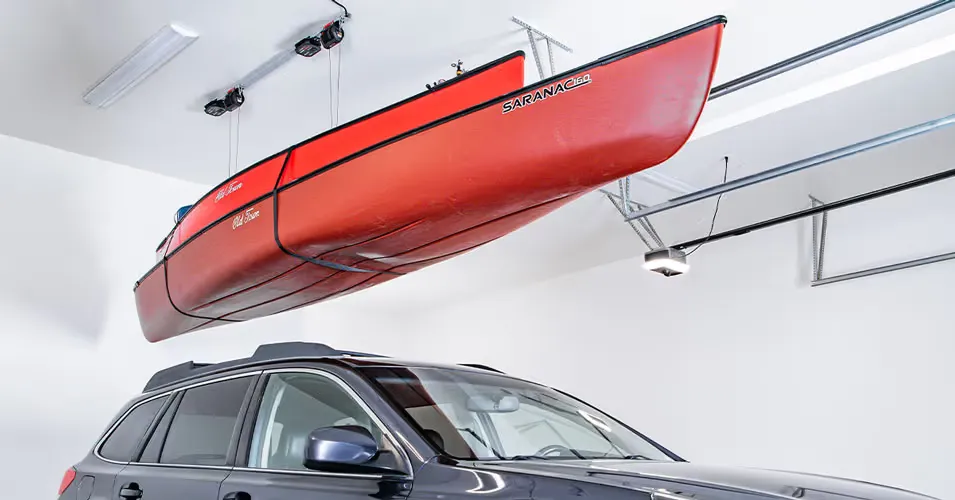 A kayak raised to the garage ceiling on a motorized lift