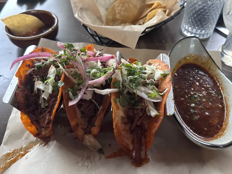 A plate of three tacos with chips and salsa in Bend