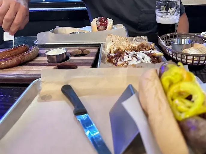 Grilled sausages, pretzels and peppers on a serving tray in Bend